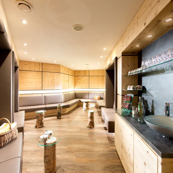 Moderne Wellness-Lounge mit Holzwänden, gemütlichen Sitzbereichen und Erfrischungsecke